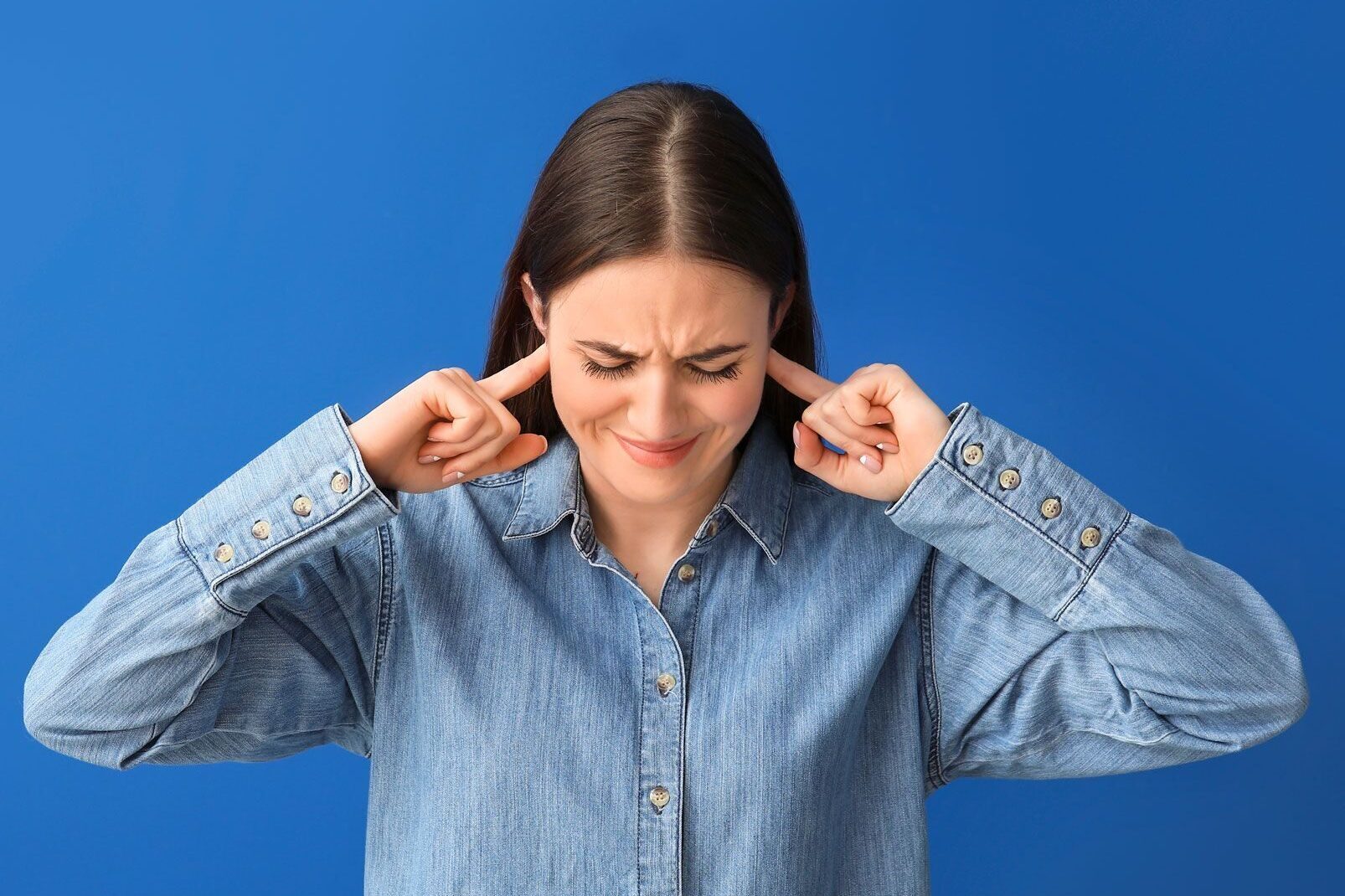 woman with fingers in her ears